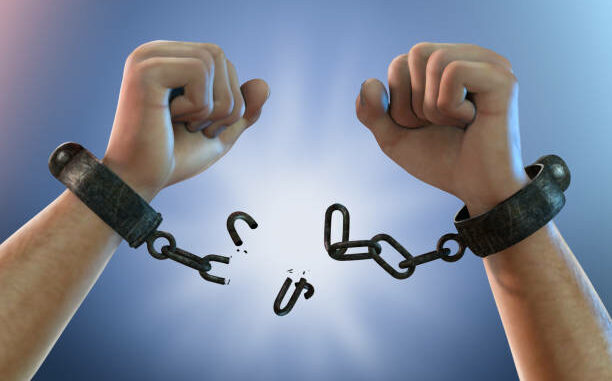 Picture of two hands with a broken chain on both wrists, depicting freedom from chains