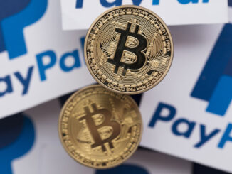 Two bitcoins on top of papers with PayPal symbol on them, representing payment methods using blockchain