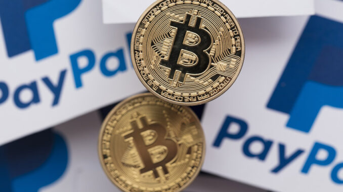 Two bitcoins on top of papers with PayPal symbol on them, representing payment methods using blockchain