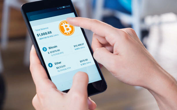 Picture of a hand holding a phone with a bitcoin wallet on it