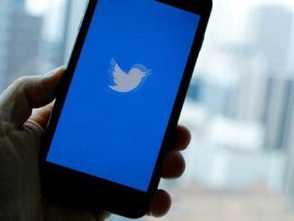 Hand holding mobile phone with Twitter open