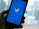 Hand holding mobile phone with Twitter open